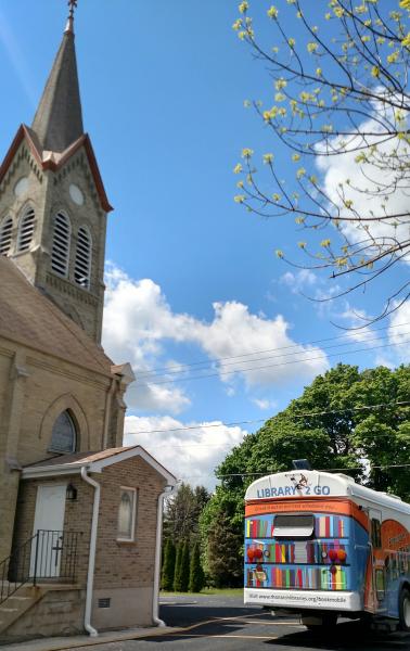 Bookmobile leaving a church parking log